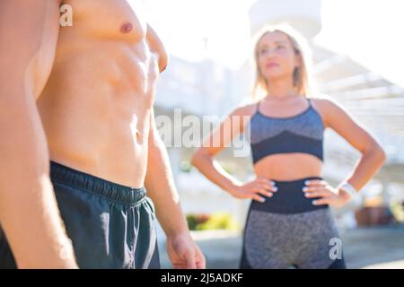 jeune couple en vêtements de sport faisant des exercices d'étirement ensemble en plein air dans les tropiques de plage d'été Banque D'Images