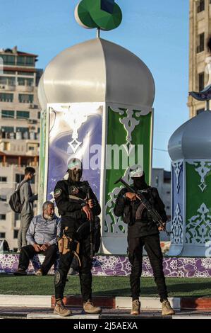 Gaza, Palestine. 21st avril 2022. Des membres des Brigades Izz al-DIN al-Qassam, l'aile militaire du mouvement islamique que le Hamas a vu dans la rue, distribuant des dates et de l'eau aux gens avant le coucher du soleil pendant le mois du Ramadan, dans la ville de Gaza. Le Ramadan est le neuvième mois du calendrier islamique et on croit que la révélation du premier verset dans le Coran a eu lieu au cours de ses 10 dernières nuits. (Photo de Mahmoud Issa/SOPA Images/Sipa USA) crédit: SIPA USA/Alay Live News Banque D'Images