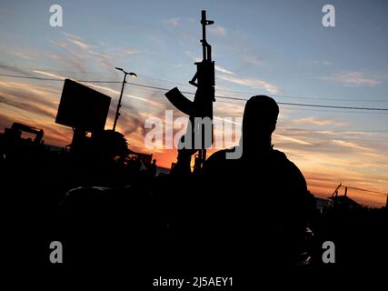 Gaza, Palestine. 21st avril 2022. Des membres des Brigades Izz al-DIN al-Qassam, l'aile militaire du mouvement islamique que le Hamas a vu dans la rue, distribuant des dates et de l'eau aux gens avant le coucher du soleil pendant le mois du Ramadan, dans la ville de Gaza. Le Ramadan est le neuvième mois du calendrier islamique et on croit que la révélation du premier verset dans le Coran a eu lieu au cours de ses 10 dernières nuits. (Photo de Mahmoud Issa/SOPA Images/Sipa USA) crédit: SIPA USA/Alay Live News Banque D'Images