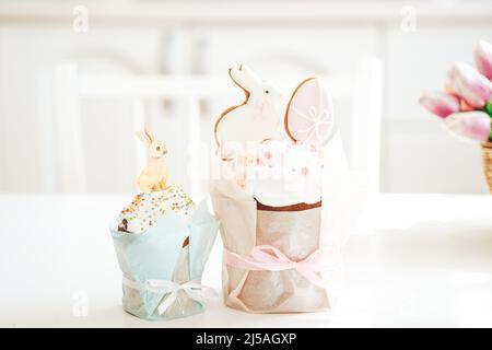 Biscuits sous forme de lapin et un oeuf sur gâteau sur table blanche Banque D'Images