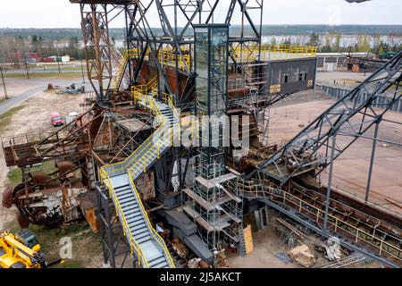 Ferropolis, Allemagne. 21st avril 2022. 21 avril 2022, Saxe-Anhalt, Gräfenhainichen: Le travail final sur la nouvelle plate-forme d'observation et l'ascenseur de verre associé est en cours dans la ville de la carrière de Ferropolis. L'ouverture officielle de la plate-forme sur le toit du carter moteur de l'épandeur, nommée Medusa, est prévue pour le 6 mai. La rénovation et la reconstruction auraient coûté plus de 1,2 millions d'euros. Dans l'arène Ferropolis, également connue sous le nom de ville de fer, trois excavatrices à ciel ouvert disused et deux camions d'épandage ont servi de toile de fond pour les concerts depuis l'exposition universelle Expo 2000. Banque D'Images