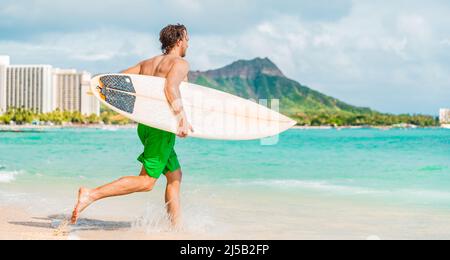 Hawaï surf style de vie jeune homme sufer aller surfer dans l'eau bleue de l'océan à Honolulu, avec Diamond Head en arrière-plan. Vacances sur l'île d'Oahu Banque D'Images