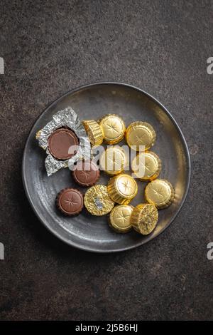 Pralines au chocolat emballées. Bonbons au chocolat sur une assiette. Vue de dessus. Banque D'Images