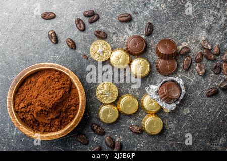 Pralines au chocolat emballées. Bonbons au chocolat et poudre de cacao dans un bol. Vue de dessus. Banque D'Images