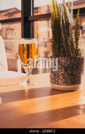 Verre de bière sur une table ensoleillée. Une délicieuse bière en verre. Banque D'Images