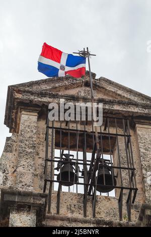 Clocher avec drapeau de la République dominicaine est sous ciel nuageux. Façade du Panthéon national de l'église des pères jésuites à Saint-Domingue, Dominic Banque D'Images