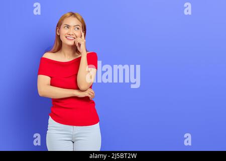 Portrait d'une jeune femme asiatique blonde et mignonne émotionnellement choquée d'avoir des idées isolées sur fond violet Banque D'Images