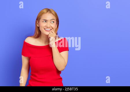 Portrait d'une jeune femme asiatique blonde et mignonne émotionnellement choquée d'avoir des idées isolées sur fond violet Banque D'Images