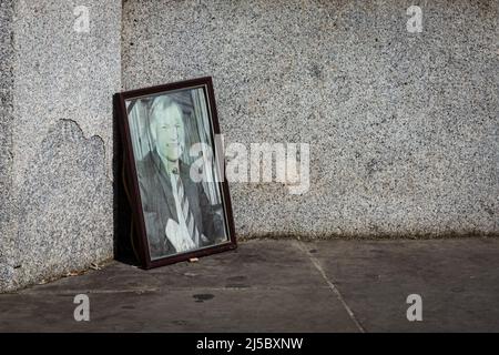 Londres, Royaume-Uni. 21st avril 2022. Une photo du député assassiné Sir David Amess est bâchée sur le trottoir juste à côté des portes d'entrée principales des chambres du Parlement, quelques mois seulement après la tenue d'un service commémoratif à l'abbaye de Westminster. Les gens marchent devant la photographie, qui avait autrefois des fleurs et des hommages à côté de lui apparemment inconscient à elle d'être là. Amess a été mortellement poignardé dans son bureau de circonscription par un attaquant en octobre 2021. Credit: Imagetraceur/Alamy Live News Banque D'Images