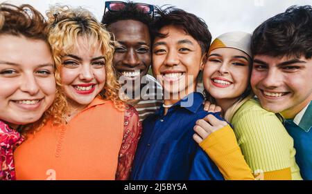 Jeunes gens divers qui s'amusent en plein air riant ensemble - concentrez-vous sur deux visages d'homme au centre Banque D'Images