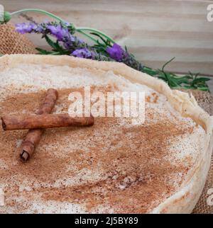 Tarte au lait cuite. Une version au four de tarte au lait traditionnelle sud-africaine ou de melktert, avec de la cannelle et une table rustique Banque D'Images