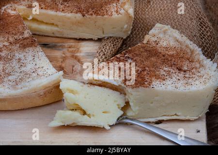 Tarte au lait cuite. Une version au four de tarte au lait traditionnelle sud-africaine ou de melktert, avec de la cannelle et une table rustique Banque D'Images