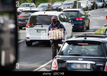 Düsseldorf, Allemagne. 21st avril 2022. Une personne supplie pour des almes, mendiant, avec un signe 'FAIM' à un carrefour à Düsseldorf, le 21 avril 2022. Credit: dpa/Alay Live News Banque D'Images