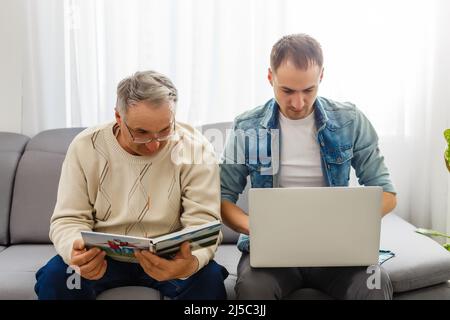 Parents et fils regardent ensemble des photos dans le livre photo à la maison Banque D'Images