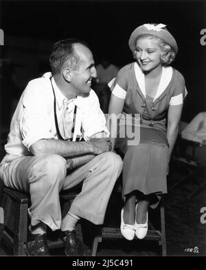 Directeur GEORGE MARSHALL sur le terrain Candid avec Set Visitor CLAIRE TREVOR (travaillant sur BÉBÉ PRENDRE Un ARC avec Shirley Temple à l'époque) pendant le tournage de elle A APPRIS SUR LES MARINS 1934 réalisateur GEORGE MARSHALL Fox film Corporation Banque D'Images