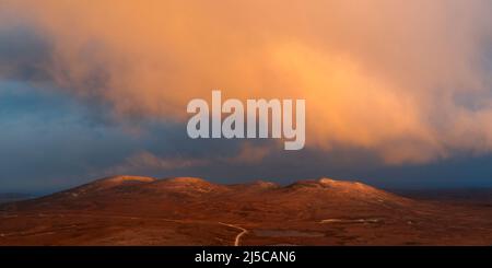 Nuages éclairés au lever du soleil sur la montagne écossaise Banque D'Images