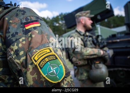 Rukla, Lituanie. 22nd avril 2022. Les soldats de la Bundeswehr de la force opérationnelle de l'OTAN « présence avancée renforcée » (EFP) se tiennent devant un char « Wiesel » lors d'une visite du ministre des Affaires étrangères Baerbock. Credit: Michael Kappeller/dpa/Alay Live News Banque D'Images