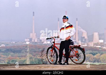 Bottrop, DEU, 12.11.1995 - Homme avec Adidas DFB veste d'entraînement de la coupe du monde 90, sur le chemin avec vélo sur le tas de scories à la Beckstrasse à Bottrop, en arrière-plan la centrale de Veba Ruhr à Gelsenkirchen est à voir. [traduction automatique] Banque D'Images