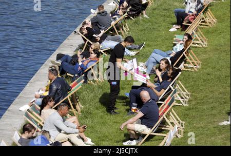 Berlin, DEU, 17.05.2020 - Un serveur portant un masque facial sert des clients dans un café animé sur la Spree à Berlin. L'Allemagne s'ouvre à nouveau lentement. Après le confinement, les magasins, les cafés et les restaurants sont maintenant progressivement autorisés à servir à nouveau les clients. Cependant, les clients et les serveurs doivent respecter les règles de distance et d'hygiène. [traduction automatique] Banque D'Images