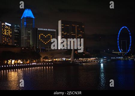 5/28/2020, Singapour, République de Singapour, Asie - manifester la solidarité à travers les fenêtres illuminées d'un hôtel en forme de coeur sur le front de mer de Marina Bay pendant le couvre-feu au milieu de la crise de Corona (Covid-19). Comme un geste d'unité et de solidarité, certains bâtiments et monuments ont également été baignés de lumière bleue chaque jeudi au cours du mois de mai (voir bleu). [traduction automatique] Banque D'Images