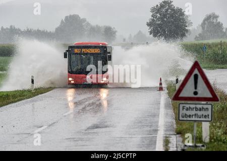 Après une forte pluie persistante, un bus vous conduira sur la route inondée entre Penzberg et Sindelsdorf. [traduction automatique] Banque D'Images