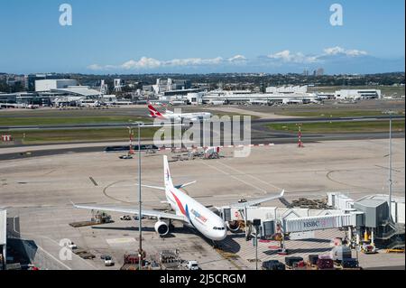 28 septembre 2019, Sydney, Nouvelle-Galles du Sud, Australie - Un Airbus A330-300 de Malaysia Airlines se met en stationnement à la porte de l'aéroport international Kingsford Smith, tandis qu'un avion de passagers de la compagnie aérienne australienne Qantas touche la piste en arrière-plan. [traduction automatique] Banque D'Images