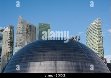 05 janvier 2021, Singapour, République de Singapour, Asie - les travailleurs effectuent l'entretien de la façade en verre bombé du nouveau magasin phare d'Apple à Marina Bay Sands, avec les gratte-ciels du quartier des affaires en arrière-plan. L'architecture futuriste du magasin de détail moderne est en forme de boule de verre géante flottant sur l'eau et est le troisième magasin Apple dans la ville-état d'Asie du Sud-est. Le bâtiment a été conçu par l'architecte anglais Sir Norman Foster (Foster et Partners). L'économie de la métropole financière, qui est fortement tributaire du commerce, a souffert le pire Banque D'Images