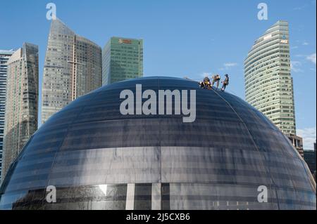 05 janvier 2021, Singapour, République de Singapour, Asie - les travailleurs effectuent l'entretien de la façade en verre bombé du nouveau magasin phare d'Apple à Marina Bay Sands, avec les gratte-ciels du quartier des affaires en arrière-plan. L'architecture futuriste du magasin de détail moderne est en forme de boule de verre géante flottant sur l'eau et est le troisième magasin Apple dans la ville-état d'Asie du Sud-est. Le bâtiment a été conçu par l'architecte anglais Sir Norman Foster (Foster et Partners). L'économie de la métropole financière, qui est fortement tributaire du commerce, a souffert le pire Banque D'Images