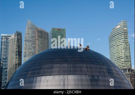 05 janvier 2021, Singapour, République de Singapour, Asie - les travailleurs effectuent l'entretien de la façade en verre bombé du nouveau magasin phare d'Apple à Marina Bay Sands, avec les gratte-ciels du quartier des affaires en arrière-plan. L'architecture futuriste du magasin de détail moderne est en forme de boule de verre géante flottant sur l'eau et est le troisième magasin Apple dans la ville-état d'Asie du Sud-est. Le bâtiment a été conçu par l'architecte anglais Sir Norman Foster (Foster et Partners). L'économie de la métropole financière, qui est fortement tributaire du commerce, a souffert le pire Banque D'Images