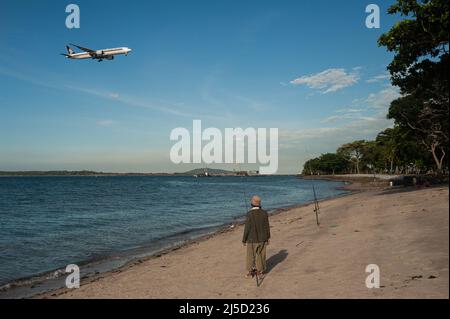 23 juin 2021, Singapour, République de Singapour, Asie - Un homme se tient sur la plage du parc de Changi Beach pendant la crise corona en cours, regardant un avion de passagers de Singapore Airlines approcher de l'aéroport international de Changi. Après un mois de mesures strictes de verrouillage dues à la hausse du taux d'infection locale, Singapour a de nouveau assoupli les restrictions et les gens sont maintenant autorisés à rencontrer jusqu'à une taille de groupe maximale de cinq personnes. [traduction automatique] Banque D'Images