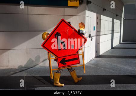 23 septembre 2021, Singapour, République de Singapour, Asie - Un travailleur dans le centre-ville porte un appareil avec des panneaux de signalisation et des feux d'avertissement pendant la crise Corona en cours. [traduction automatique] Banque D'Images