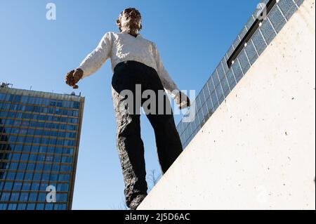 '03/12/2022, Berlin, Allemagne, Europe - la sculpture ''Balanceakt'' est une œuvre du sculpteur allemand Stephan Balkenhol qui se trouve en face du gratte-ciel Axel Springer et du nouveau bâtiment à l'angle d'Axel-Springer-Strasse et de Zimmerstrasse dans le quartier Kreuzberg de Berlin. L'œuvre consiste en un homme portant un pantalon noir et une chemise blanche équilibrant sur une pièce du mur de Berlin, ainsi que onze pièces originales du mur placées autour de la figure. Le monument est destiné à commémorer la réunification allemande et, en particulier, la chute du mur. [traduction automatique]' Banque D'Images