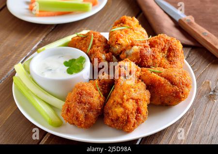 Ailes de poulet grillées et sauce sur une assiette blanche Banque D'Images