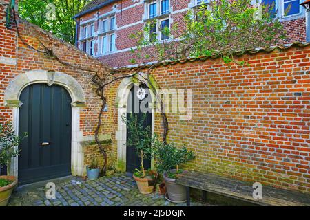 Lier (Begijnhof), Belgique - avril 9. 2022: Vue sur la cour avant de la vieille maison médiévale, mur en brique rouge, portes en bois vert dans l'ancien village belge Banque D'Images