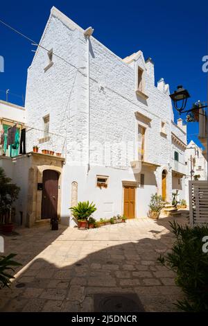 Une rue étroite typique de Locorotondo souvent décorée avec des fleurs, Apulia, Italie. Banque D'Images