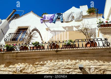 Une rue étroite typique de Locorotondo souvent décorée avec des fleurs, Apulia, Italie. Banque D'Images