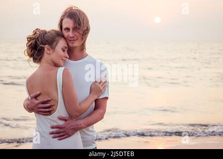 Justmaried couple courant sur une plage de sable Banque D'Images