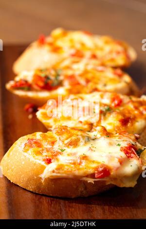 Gros plan sur l'apéritif italien bruschettas avec sauce tomate et parmesan sur la table en bois, à l'horizontale. Banque D'Images