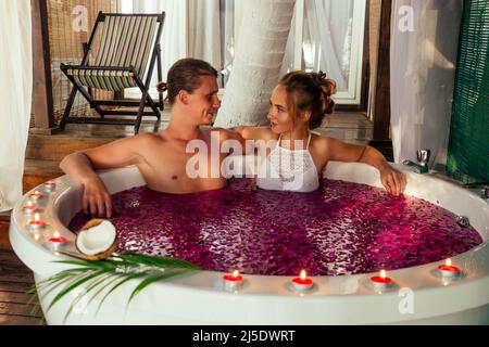 Saint Valentin jeune couple allongé dans un jacuzzi salle de bains romantique en lune de miel Banque D'Images