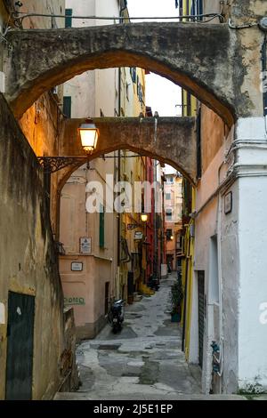 Une ruelle étroite ('caruggio') dans le centre historique de Sanremo, avec les maisons typiques de couleur pastel au crépuscule, Imperia, Ligurie, Italie Banque D'Images