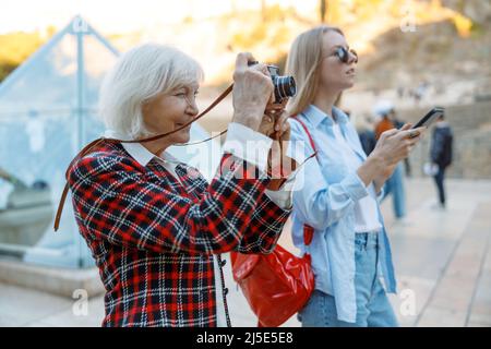 Deux femmes enthousiastes prenant des photos en ville Banque D'Images