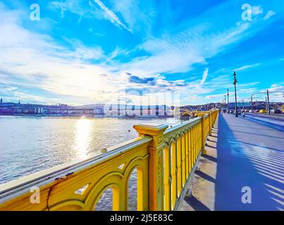 La promenade le soir le long du pont Margaret avec des rails jaune vif et une vue sur le ciel coloré et le chemin du soleil sur la syrface du Danube, Budope Banque D'Images