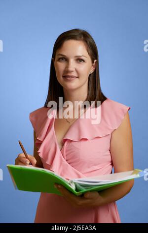 Portrait d'une jeune enseignante de race blanche debout sur fond blanc Banque D'Images