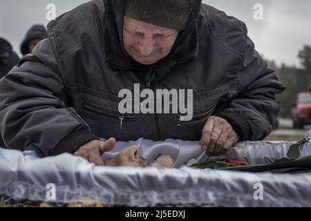 Irpin, Ukraine. 22nd avril 2022. Un homme rend hommage à Fedorenko Viktor Dmytrevych, 86 ans, dans un cimetière d'Irpin le vendredi 22 avril 2022. Dmytrevych était chirurgien et est mort d'une pneumonie causée par la COVID après avoir vécu et caché dans un sous-sol pendant un mois chez les soldats russes. Un commandant militaire à Moscou a déclaré vendredi que l'objectif de la nouvelle phase de la guerre de la Russie est de prendre le contrôle intégral de l'Ukraine du sud et de l'est et de relier la région du Donbass à la Crimée par voie terrestre. Photo de Ken Cedeno/UPI crédit: UPI/Alay Live News Banque D'Images