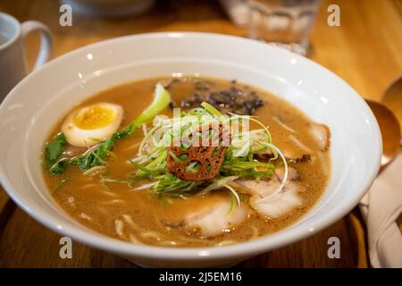 Gros plan d'un bol de miso ramen recouvert de Char Siu japonais ou de porc japonais, d'œuf de jaune mou, de échalotes, de racine de lotus séchée, de champignon noir et de végétagabl Banque D'Images