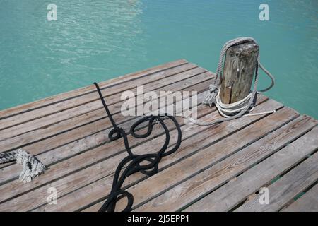 Borne d'amarrage en bois sur un quai en bois au-dessus de l'eau de l'océan Banque D'Images