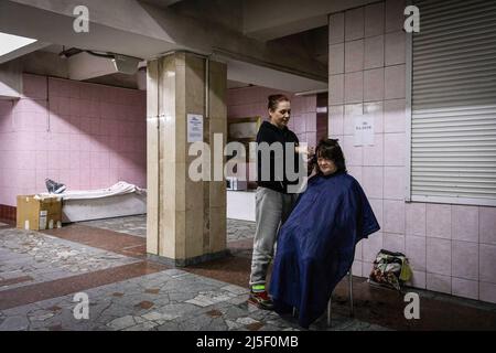 19 avril 2022, Kharkiv, Kharkivs''ka Oblast', Ukraine : une femme qui obtient une coupe de cheveux dans une station de métro. Les citoyens de Kharkiv ont été contraints d’adopter une nouvelle vie sous terre dans les stations de métro, alors que la deuxième plus grande ville d’Ukraine est aujourd’hui confrontée à une menace constante de bombardements et de frappes aériennes russes. (Image de crédit : © Alex Chan TSZ Yuk/SOPA Images via ZUMA Press Wire) Banque D'Images