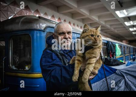 19 avril 2022, Kharkiv, Kharkivs''ka Oblast', Ukraine: Un homme pose pour une photo avec son chat, dans une station de métro. Les citoyens de Kharkiv ont été contraints d’adopter une nouvelle vie sous terre dans les stations de métro, alors que la deuxième plus grande ville d’Ukraine est aujourd’hui confrontée à une menace constante de bombardements et de frappes aériennes russes. (Image de crédit : © Alex Chan TSZ Yuk/SOPA Images via ZUMA Press Wire) Banque D'Images