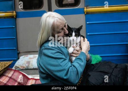 19 avril 2022, Kharkiv, Kharkivs''ka Oblast', Ukraine: Une vieille dame embrassant son chat dans une station de métro. Les citoyens de Kharkiv ont été contraints d’adopter une nouvelle vie sous terre dans les stations de métro, alors que la deuxième plus grande ville d’Ukraine est aujourd’hui confrontée à une menace constante de bombardements et de frappes aériennes russes. (Image de crédit : © Alex Chan TSZ Yuk/SOPA Images via ZUMA Press Wire) Banque D'Images