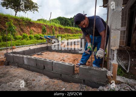 Un ouvrier de la construction est en voie de construire une nouvelle maison à Las Minas de Tulu, province de Cocle, République de Panama, Amérique centrale. Banque D'Images